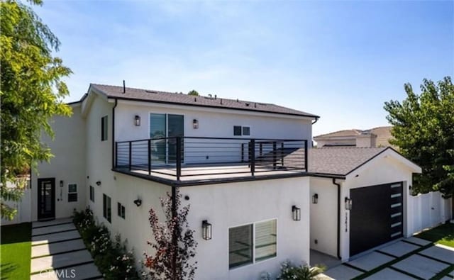 view of front of home with a garage, fence, and stucco siding