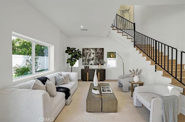 living area with a towering ceiling, stairs, visible vents, and recessed lighting