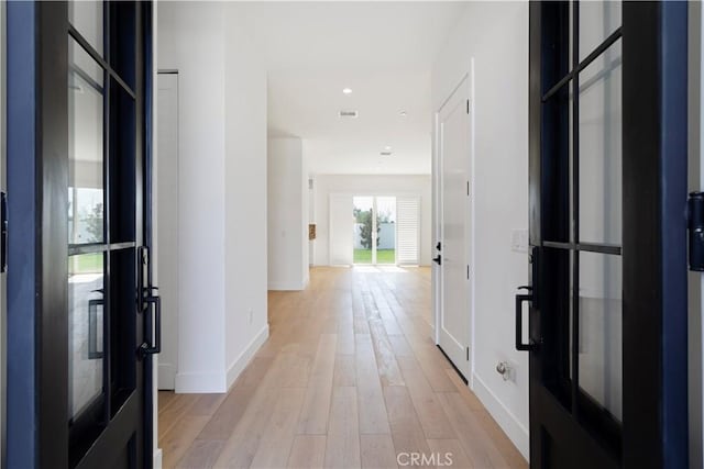 hall featuring recessed lighting, light wood-type flooring, visible vents, and baseboards