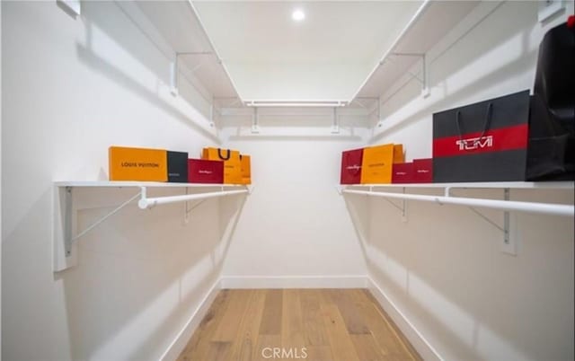 walk in closet with wood finished floors