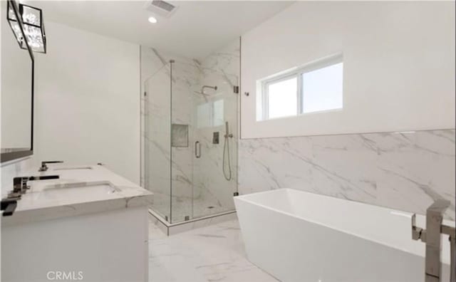 full bath with double vanity, a marble finish shower, visible vents, marble finish floor, and a freestanding bath