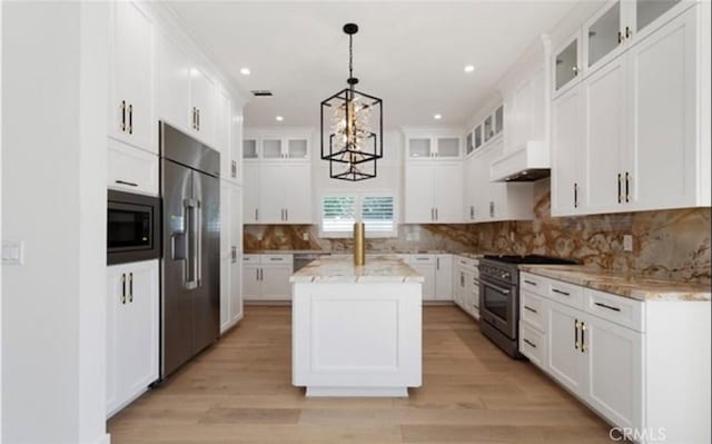 kitchen with decorative backsplash, a kitchen island, glass insert cabinets, high quality appliances, and white cabinetry