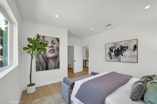 bedroom featuring baseboards, wood finished floors, visible vents, and recessed lighting