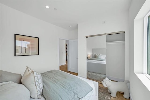 bedroom featuring multiple windows, baseboards, a closet, and recessed lighting