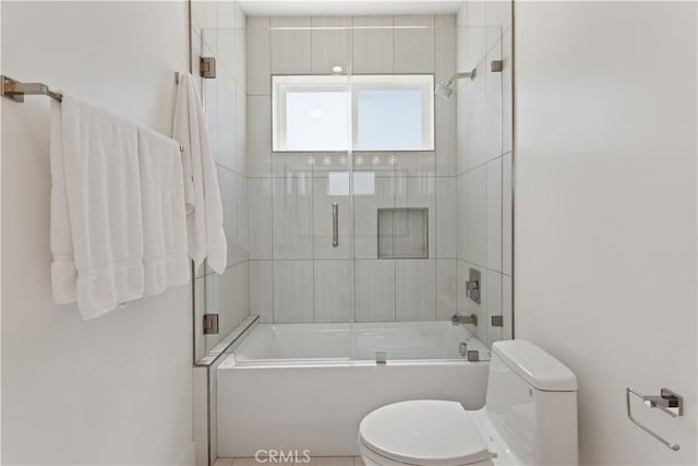 full bathroom featuring toilet and combined bath / shower with glass door