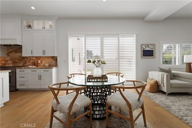 dining space featuring light wood finished floors and recessed lighting