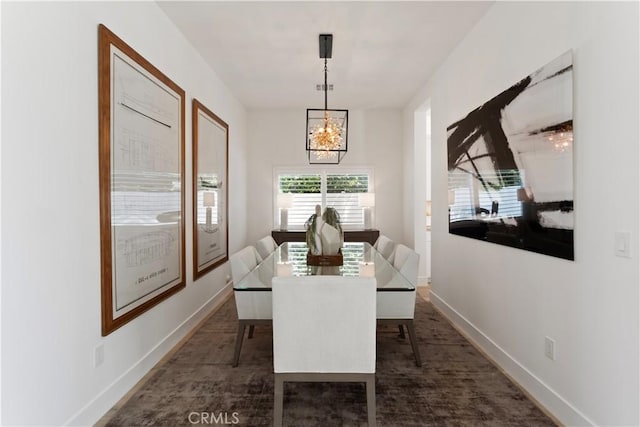 dining space featuring a notable chandelier and baseboards