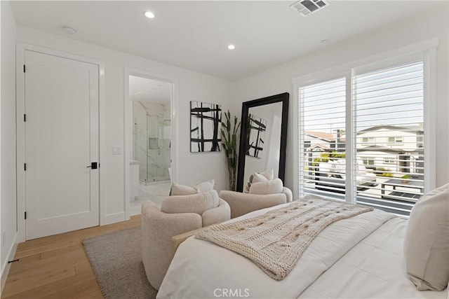 bedroom featuring visible vents, light wood-style flooring, recessed lighting, and ensuite bathroom