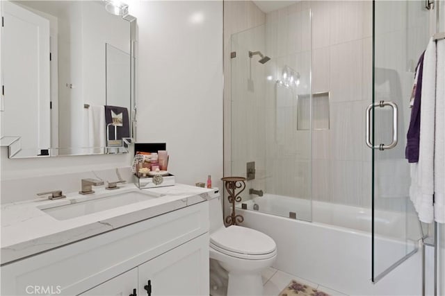 bathroom with toilet, vanity, and shower / bath combination with glass door