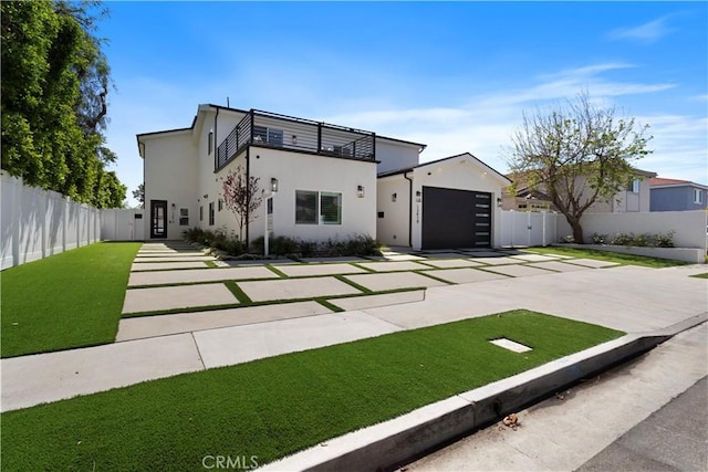 modern home with fence, driveway, stucco siding, and a balcony