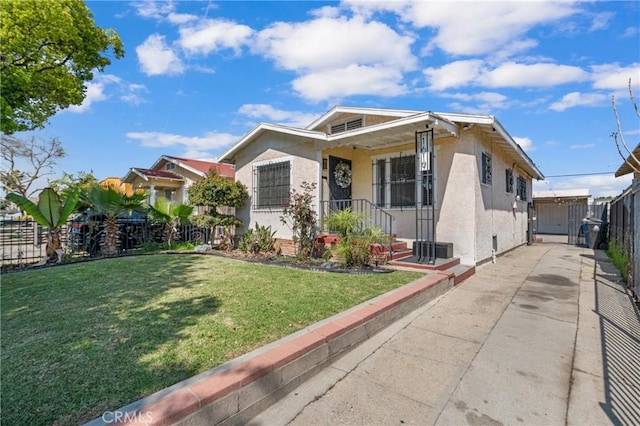 bungalow with stucco siding, driveway, and fence