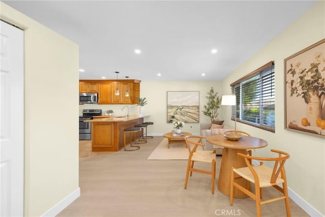 dining space featuring recessed lighting, baseboards, and light wood finished floors