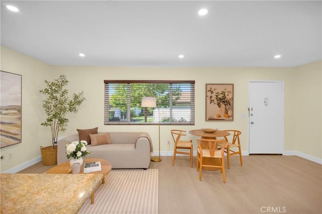 living room featuring light wood finished floors, recessed lighting, and baseboards