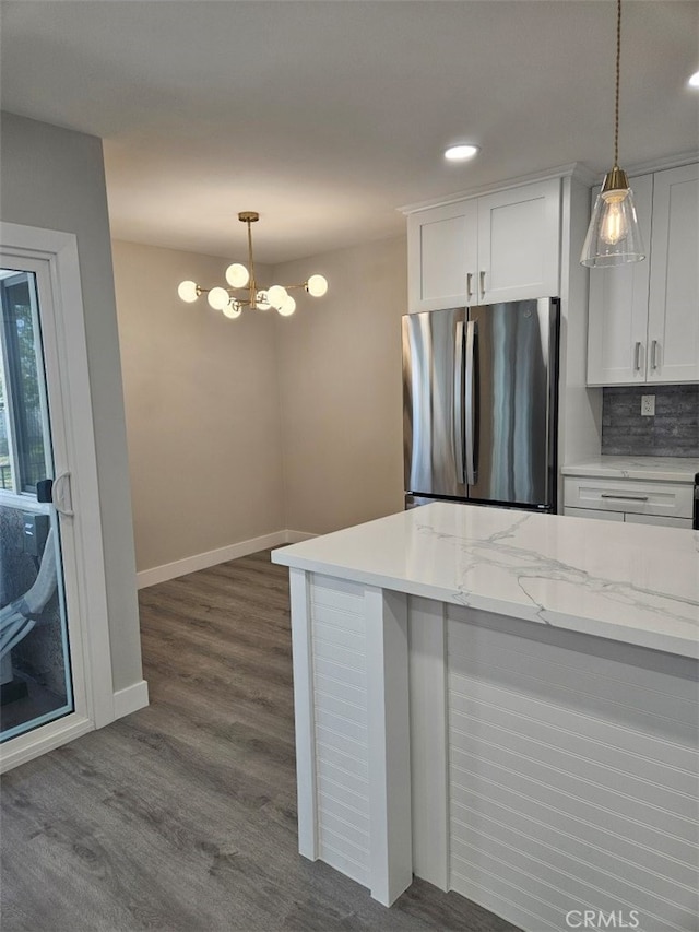 kitchen featuring freestanding refrigerator, pendant lighting, white cabinets, and dark wood-style flooring