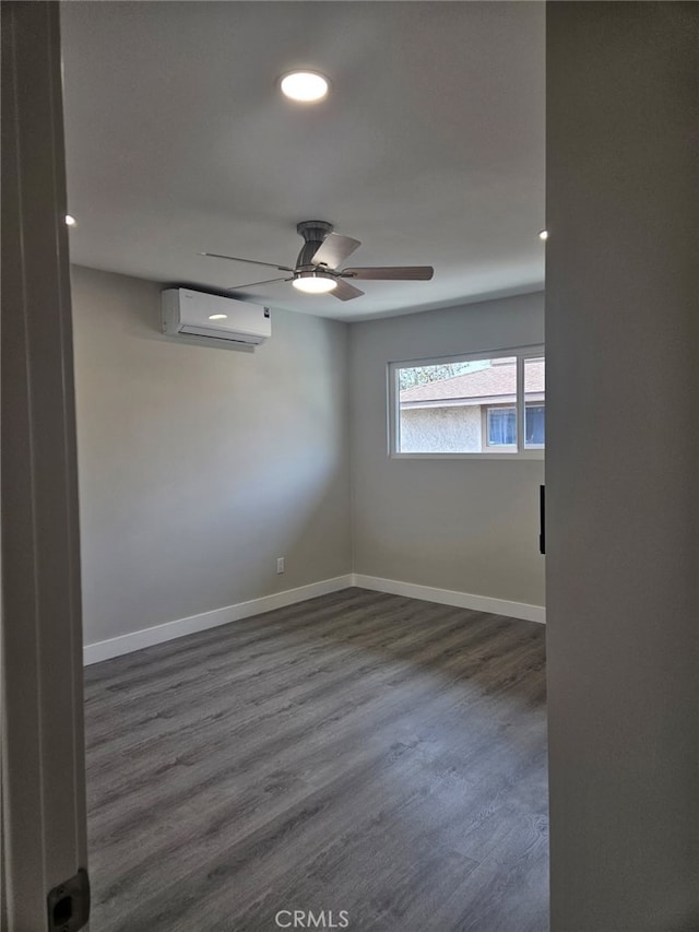 empty room with recessed lighting, dark wood-type flooring, a ceiling fan, an AC wall unit, and baseboards