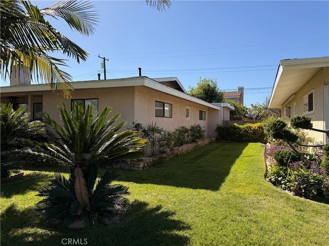 view of property exterior featuring a lawn and stucco siding