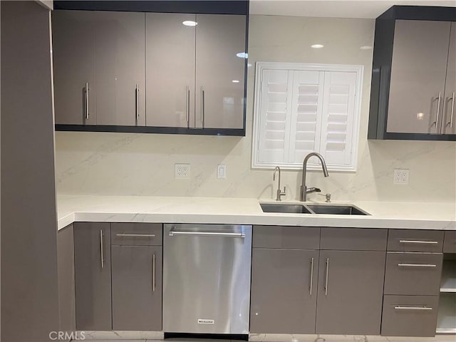 kitchen with decorative backsplash, gray cabinets, a sink, and stainless steel dishwasher