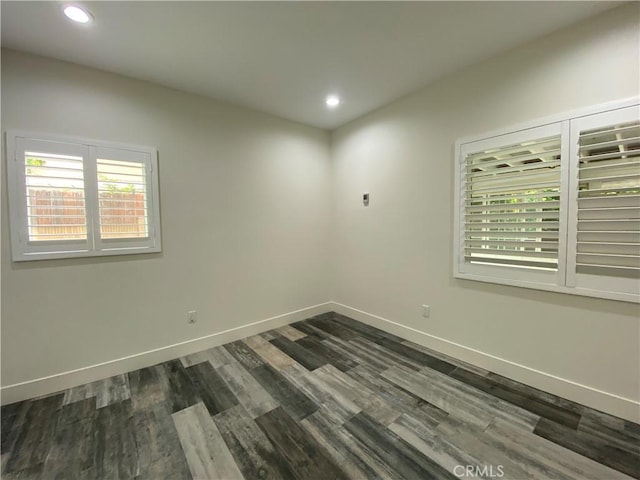 spare room with dark wood-style flooring, recessed lighting, and baseboards