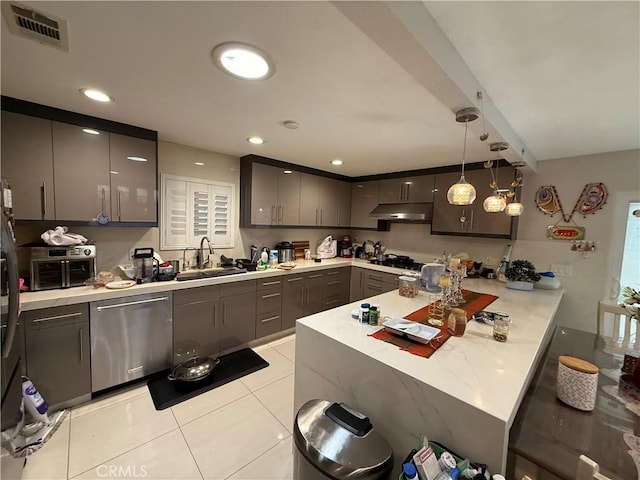 kitchen with visible vents, stainless steel dishwasher, a sink, a peninsula, and under cabinet range hood