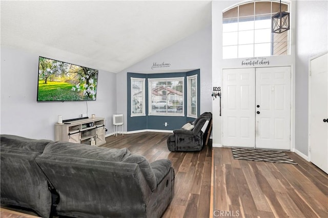 living room with baseboards, high vaulted ceiling, and hardwood / wood-style floors