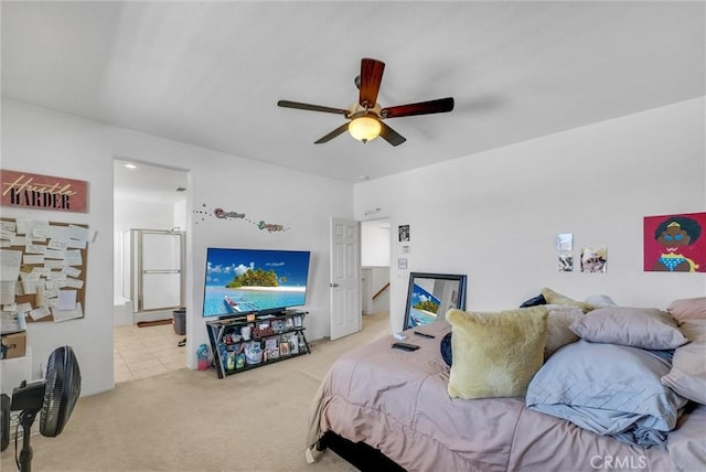 bedroom with carpet floors, ceiling fan, and ensuite bath