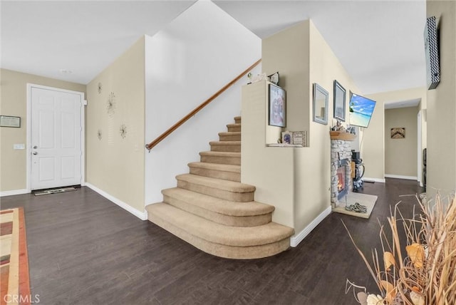 foyer entrance featuring stairway, baseboards, and wood finished floors