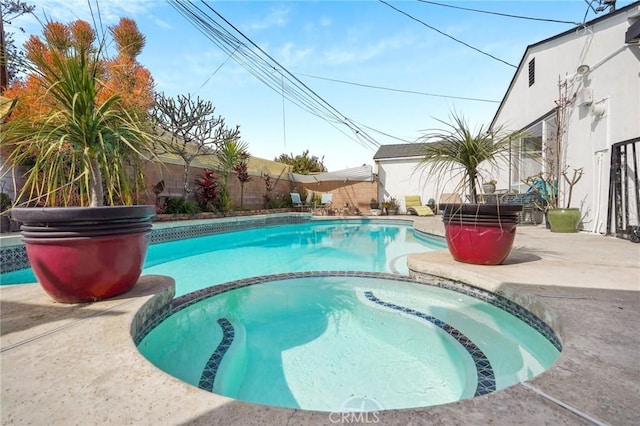 view of swimming pool with a patio and a pool with connected hot tub