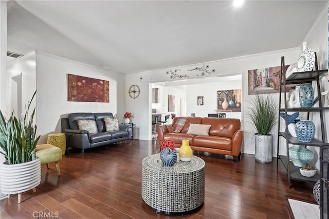 living room featuring vaulted ceiling, visible vents, ornamental molding, and hardwood / wood-style floors