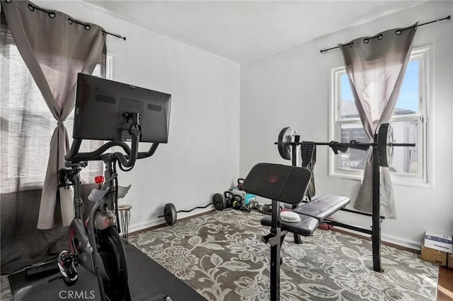 workout area featuring wood finished floors and baseboards