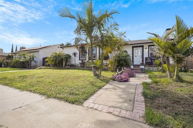 view of front of house with stucco siding and a front lawn