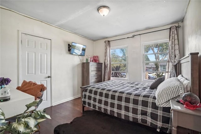 bedroom with baseboards and wood finished floors