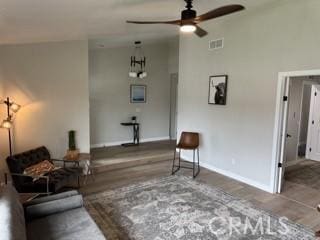 living area with baseboards, visible vents, a ceiling fan, wood finished floors, and high vaulted ceiling