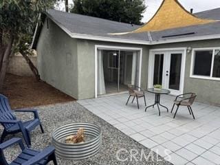 back of property with french doors, a patio area, and stucco siding