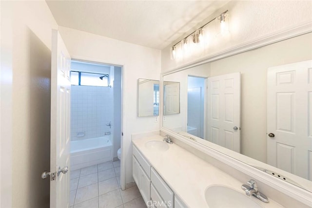 full bath featuring double vanity, tile patterned flooring, a sink, and toilet