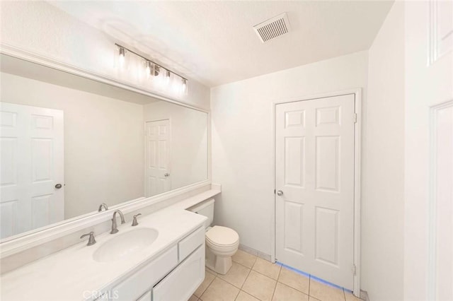 bathroom with toilet, vanity, visible vents, and tile patterned floors