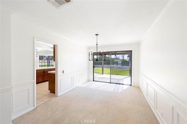 empty room featuring a healthy amount of sunlight, visible vents, a notable chandelier, and light colored carpet