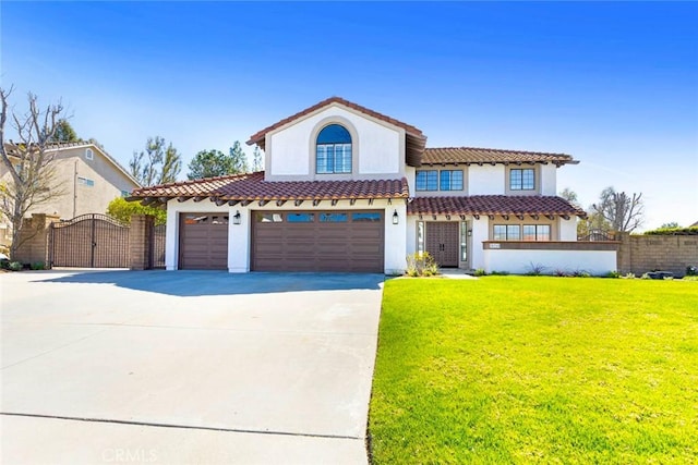 mediterranean / spanish home featuring concrete driveway, a tile roof, a gate, fence, and a front yard