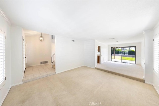 empty room featuring light carpet, a chandelier, and visible vents