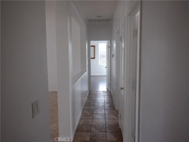 corridor featuring baseboards and visible vents