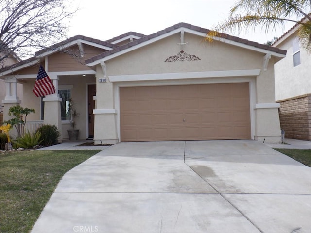 view of front of home featuring a garage, concrete driveway, a tiled roof, and stucco siding