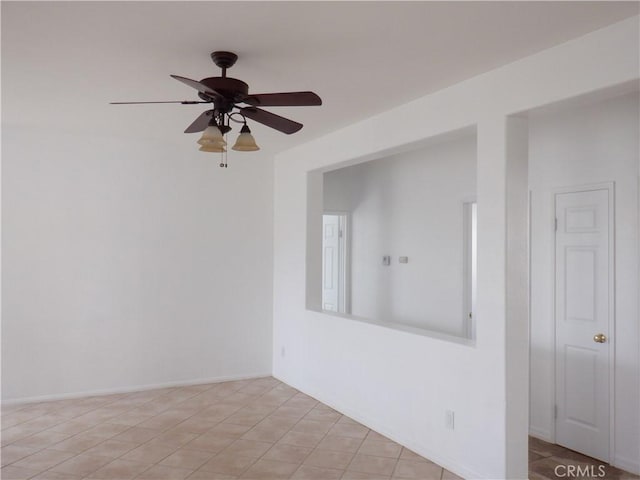 spare room featuring ceiling fan and baseboards