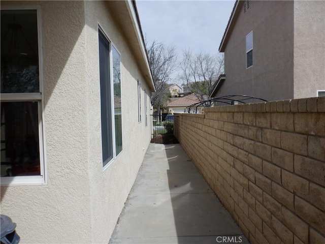 view of home's exterior with fence and stucco siding