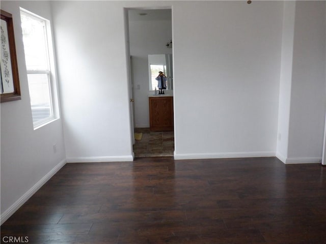 unfurnished room featuring baseboards and wood finished floors