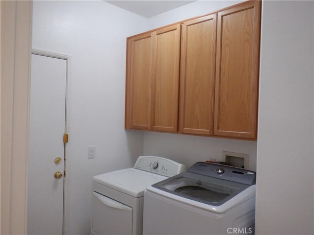 washroom featuring washer and clothes dryer and cabinet space