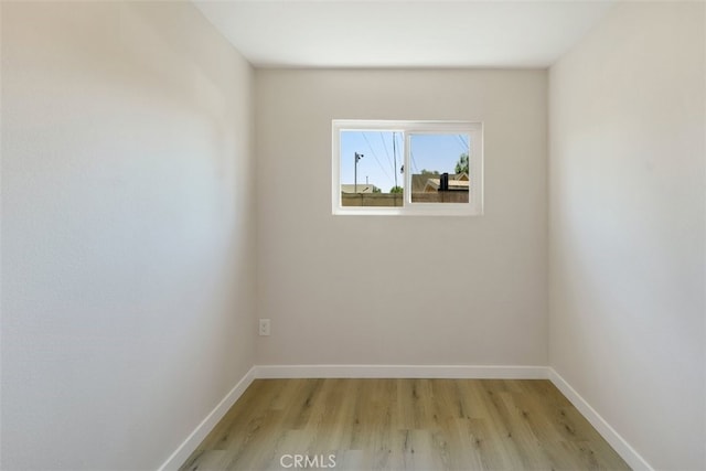 spare room with light wood-type flooring and baseboards