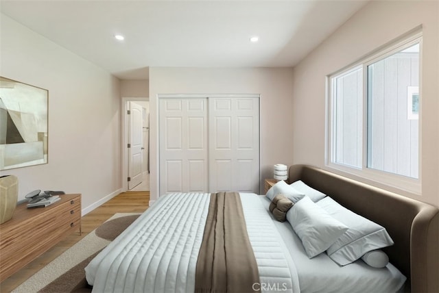 bedroom featuring baseboards, a closet, wood finished floors, and recessed lighting