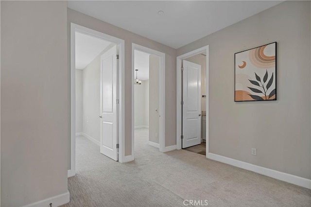 hall featuring carpet flooring and baseboards