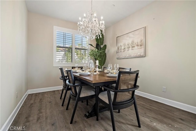 dining room with a notable chandelier, baseboards, and wood finished floors