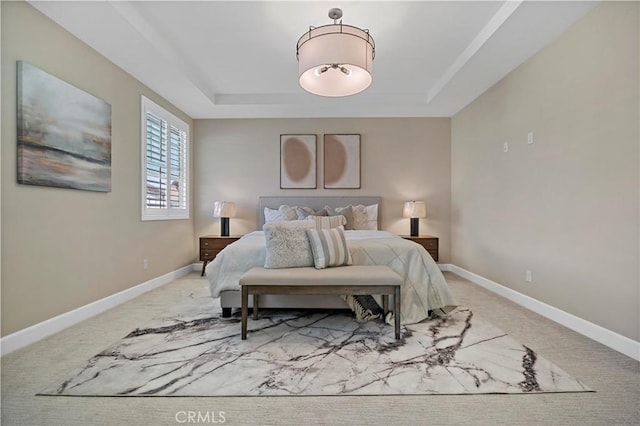 bedroom with carpet, baseboards, and a tray ceiling