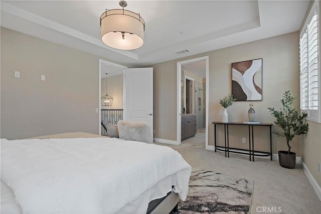 bedroom featuring baseboards, a tray ceiling, visible vents, and light colored carpet